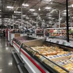 Supermarket dairy aisle with refrigerated cheese display cases